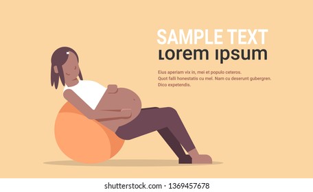 pregnant woman sitting on gymnastic ball african american girl exercises with fitball working out fitness pregnancy healthy lifestyle concept full length horizontal copy space