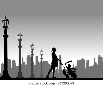 Pregnant woman walking with baby in tricycle on the street,