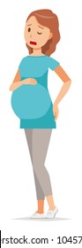 A pregnant woman wearing blue clothes is touching her low back