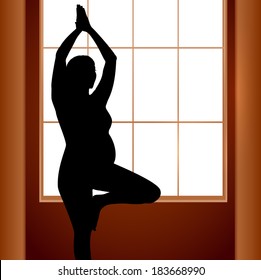 Pregnant woman in yoga position near window