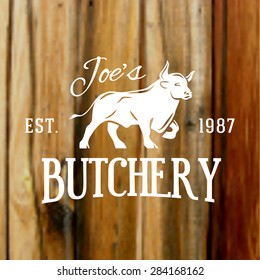 Premium vintage beef bull label on blurred wood background. Vector butchery logo design.