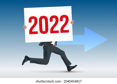 To present a company’s future strategy, a businessman runs while carrying a white sign with 2022 written on it.