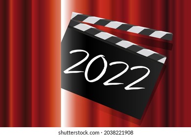 To present the new year, a movie clapperboard with the inscription 2022 passes through the red curtain of a performance stage.