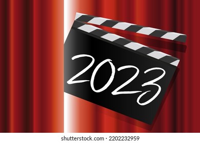 To present the new year, a movie clapperboard with the inscription 2023 passes through the red curtain of a performance stage.