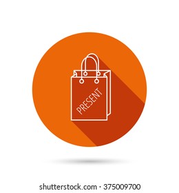 Present shopping bag icon. Gift handbag sign. Round orange web button with shadow.