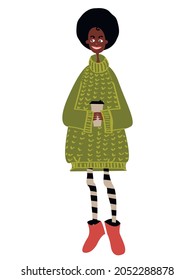 A pretty dark-skinned young woman stands and smiles in a fashionable olive oversize sweater and striped tights with a disposable cup of coffee in her hands isolated.