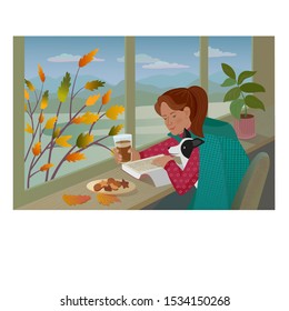 Pretty girl with dog reads the book and drinks the coffee seating next to the window.There is a pictorial autumn landscape with mountains and tree with yellow leaves outside the window.