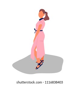 Pretty girl is standing in pink long dress. Woman turned sideways in blue sandals.