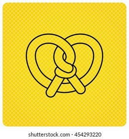 Pretzel icon. Bakery food sign. Traditional bavaria snack symbol. Linear icon on orange background. Vector