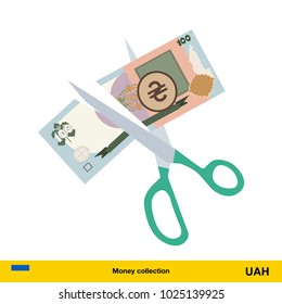 Price or cost reduction concept. Scissors cutting money bill.  hryvnia banknote.