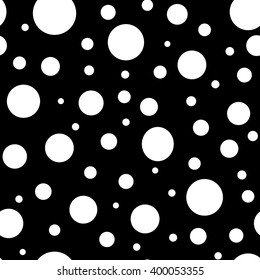 Print with white circles on a black background. Polka dot pattern. Circles of different sizes. 