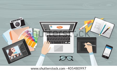 Professional creative graphic designer working at office desk, he is designing a vector illustration using a laptop
