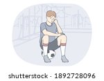 Professional football player, soccer ball, sport concept. Young unhappy boy football player sitting on soccer ball and feeling sad after failure during workout or game. Sport, athletics, team sport 