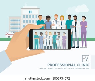 Professional medical staff and doctor posing together at the hospital, a man is taking a picture using a smartphone