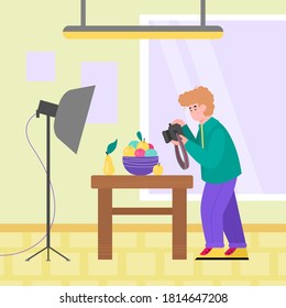 Professional photographer cartoon character making photo shoot of still life, flat vector illustration. Man photographing fruits on table