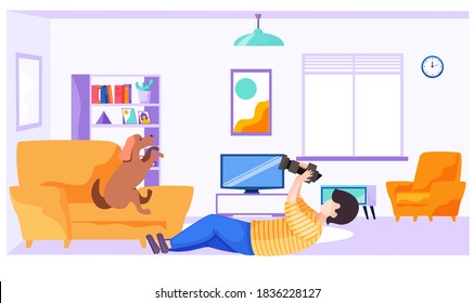 Professional photographer makes pictures of a dog standing on the armchair. Guy with the camera takes pictures of the pet while lying on the floor. Photo session of pet. Shooting in apartment