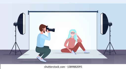 professional photographer using camera man shooting beautiful sexy woman model posing modern photo studio interior horizontal full length