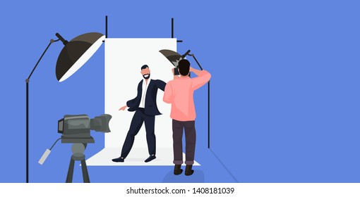 professional photographer using camera man shooting businessman in formal wear posing in modern photo studio horizontal full length flat