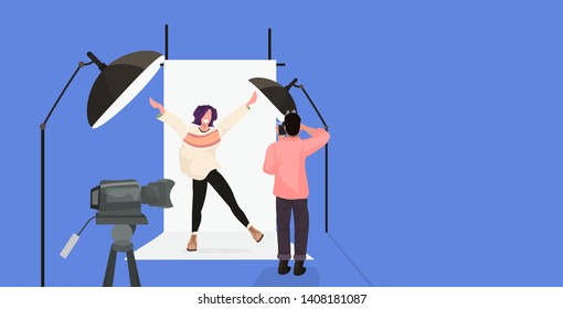 professional photographer using camera man shooting beautiful sexy woman model raising hands posing in modern photo studio horizontal full length flat