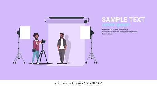 professional photographer using camera shooting business man in formal wear african american model posing in modern photo studio horizontal full length flat copy space