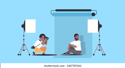 professional photographer using camera shooting business man in formal wear african american model sitting posing in modern photo studio horizontal full length flat