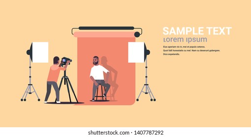 professional photographer using camera shooting business man in formal wear sitting on chair african american model posing in modern photo studio horizontal full length flat copy space