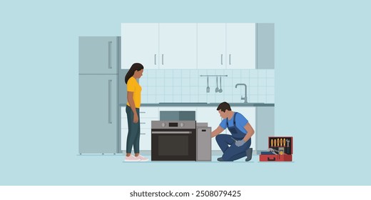 Professional repairman fixing and installing and electric oven in the kitchen, the customer is staring at him