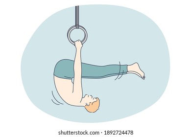 Professional sport, workout, training concept. Young man athlete gymnast doing exercises on rings during training and feeling excited and energetic. Active lifestyle, fitness, bodycare, wellness