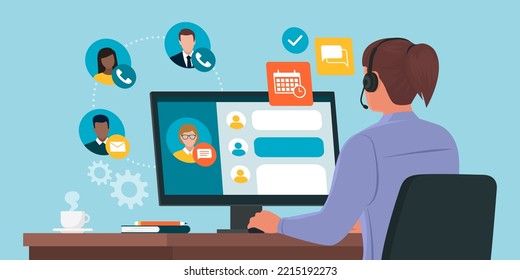 Professional virtual assistant sitting at desk and working with computer: she is talking with customers, replying to messages and planning