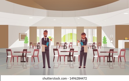 professional waiters couple standing together man woman restaurant workers in uniform holding notepad and towel taking order concept modern cafe interior flat full length horizontal