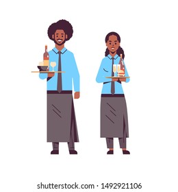 professional waiters holding bottles wine and champagne glasses on trays african american man woman restaurant workers in apron carrying alcohol drink flat full length white background