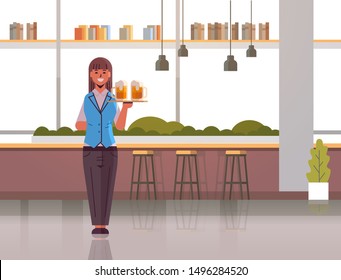 professional waitress holding serving tray with two glasses of beer woman restaurant worker in uniform carrying alcohol drinks modern pub interior flat full length horizontal