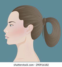 Profile of a young white woman without make up on blue background. Dark brown hair in a ponytail.