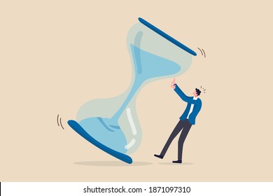 Project deadline, running out of time or time management concept, frustrated nervous businessman trying to stop hourglass or sandglass before it fall.