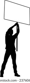 Protestor or demonstrator at a demonstration march, picket line or strike protest rally in silhouette. Holding up a banner or picket sign board placard.
