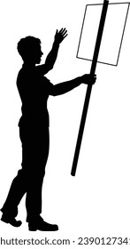 Protestor or demonstrator at a demonstration march, picket line or strike protest rally in silhouette. Holding up a banner or picket sign board placard.