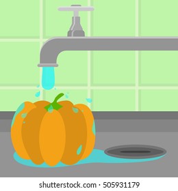 Pumpkin being cleaned and washed in a sink in a kitchen. Running tap water.