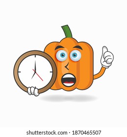 Pumpkin mascot character holding a wall clock. vector illustration