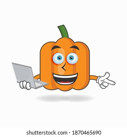 Pumpkin mascot character with laptop in right hand. vector illustration