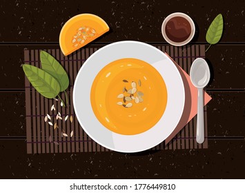 Pumpkin soup with spoon on table. Top view.