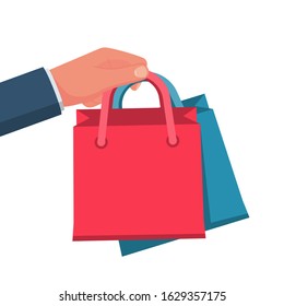 Purchases in hand. Man hold shopping. Vector illustration flat style design. Multicolored paper bags. Template for sales. Empty space for discounts and offers.