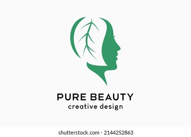 Pure beauty logo design, silhouette of woman's face blends with leaves in creative concept
