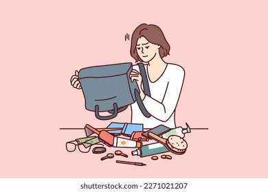 Puzzled woman shakes out contents of bag on table trying to find wallet with money or mobile phone. Girl is embarrassed because of mess in bag causing inconvenience and loss of wallet