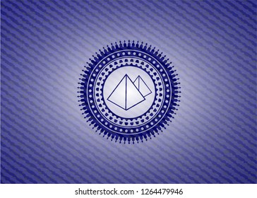 pyramids icon inside badge with denim texture