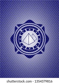 pyramids icon inside badge with denim background