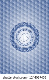pyramids icon inside blue emblem or badge with geometric pattern background.