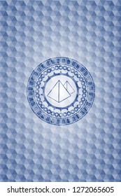 pyramids icon inside blue emblem or badge with geometric pattern background.