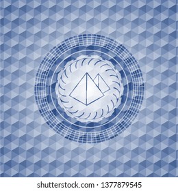 pyramids icon inside blue emblem or badge with abstract geometric pattern background.