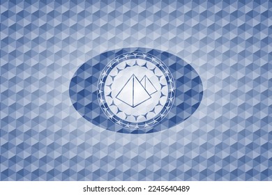 pyramids icon inside blue emblem with geometric pattern background. 