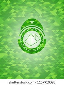 pyramids icon inside green emblem with mosaic ecological style background